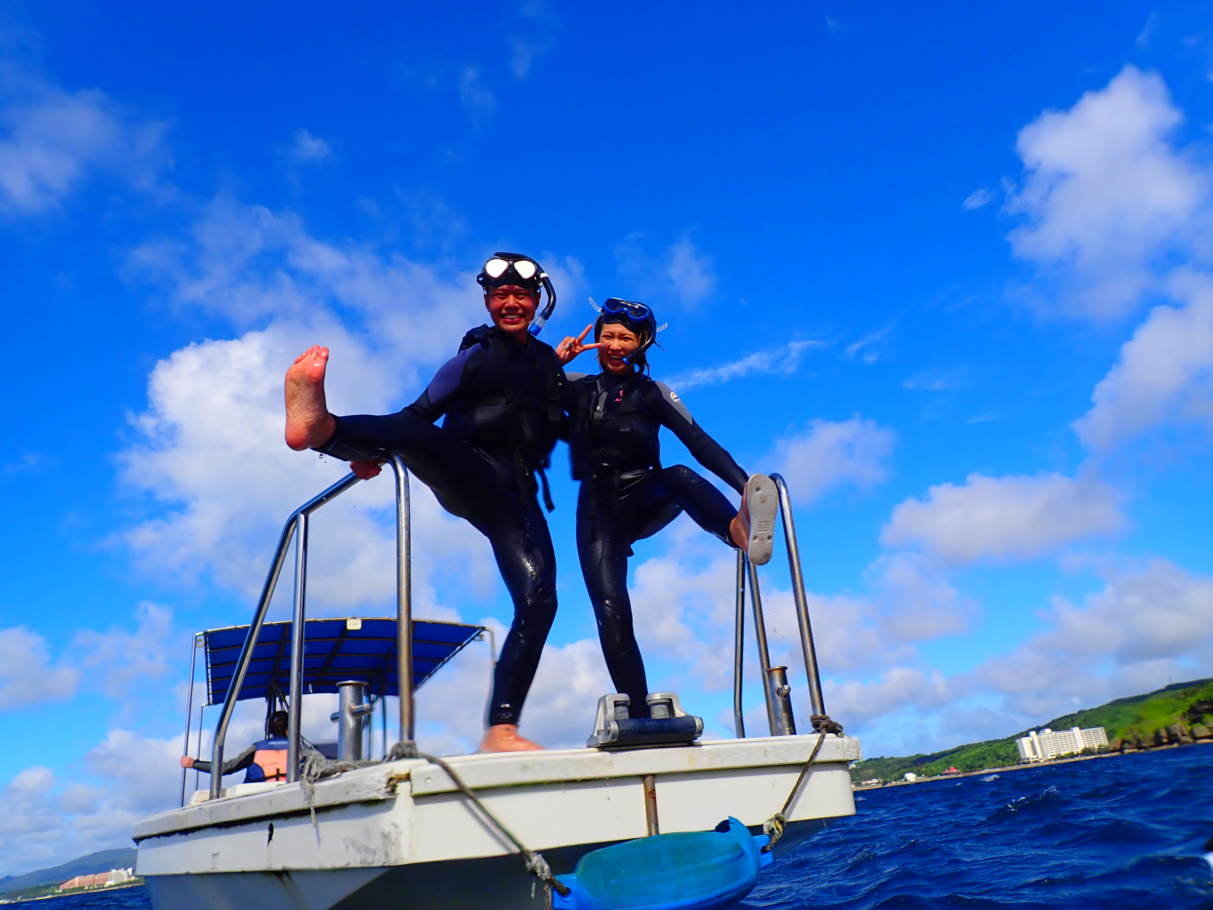 体験ダイビング前に船の上でポーズを撮るカップル