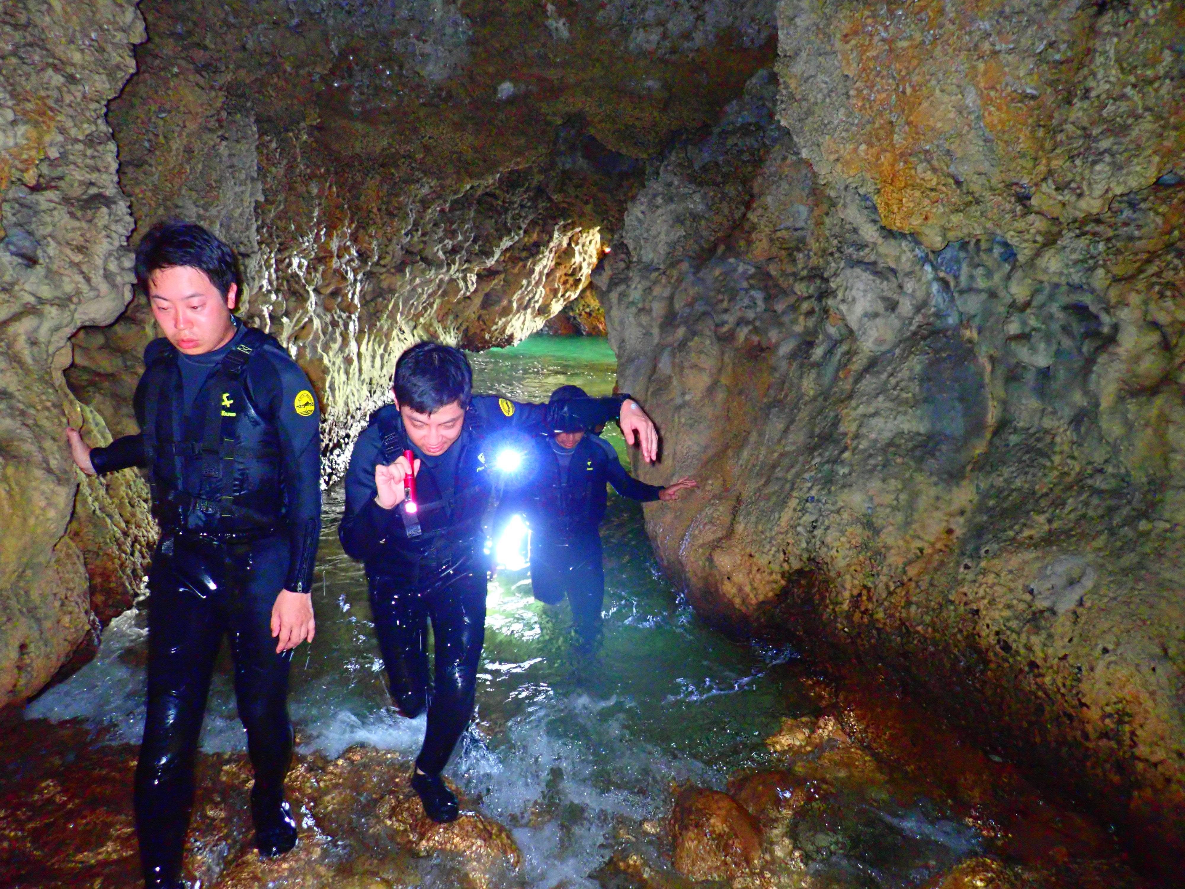 沖縄の恩納村で洞窟の中を進むグループ