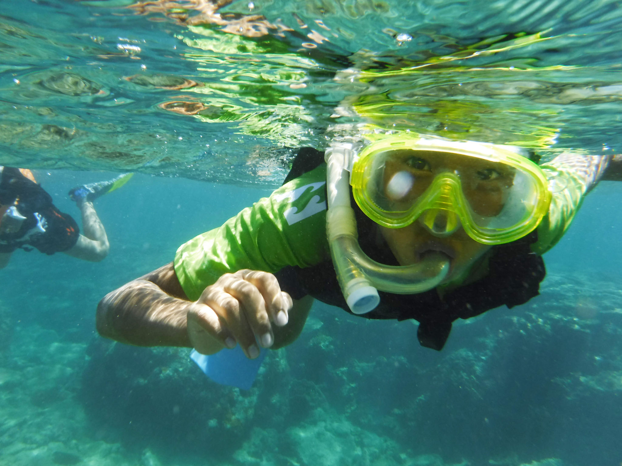 沖縄の国頭村の透明度の高い海で泳ぐ子ども