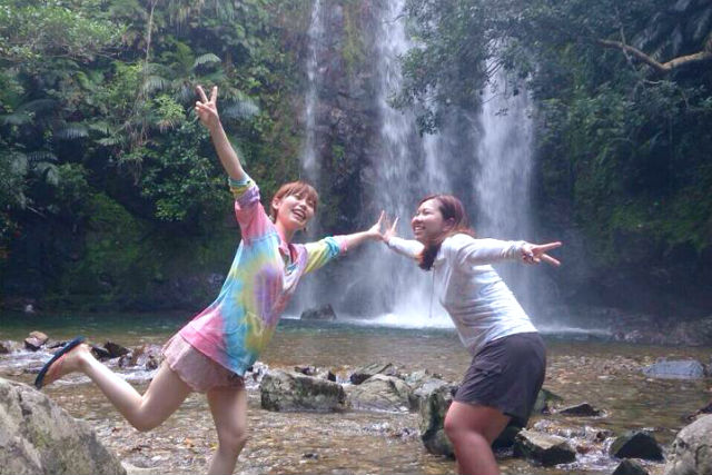 沖縄のやんばるの滝でピースする女の子たち