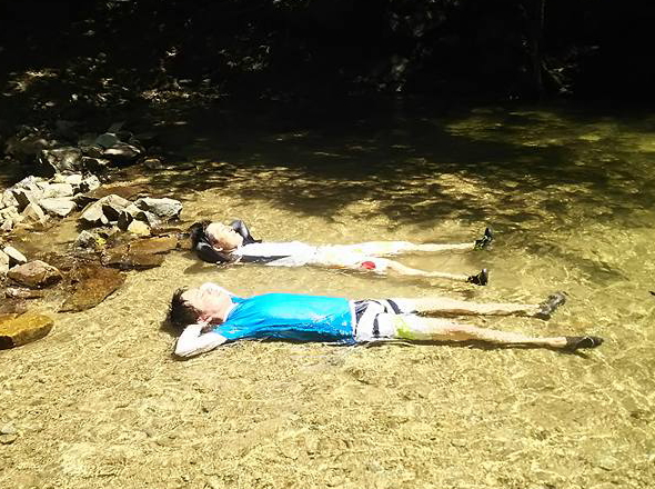 沖縄のやんばるの川の中で寝転ぶ男の子