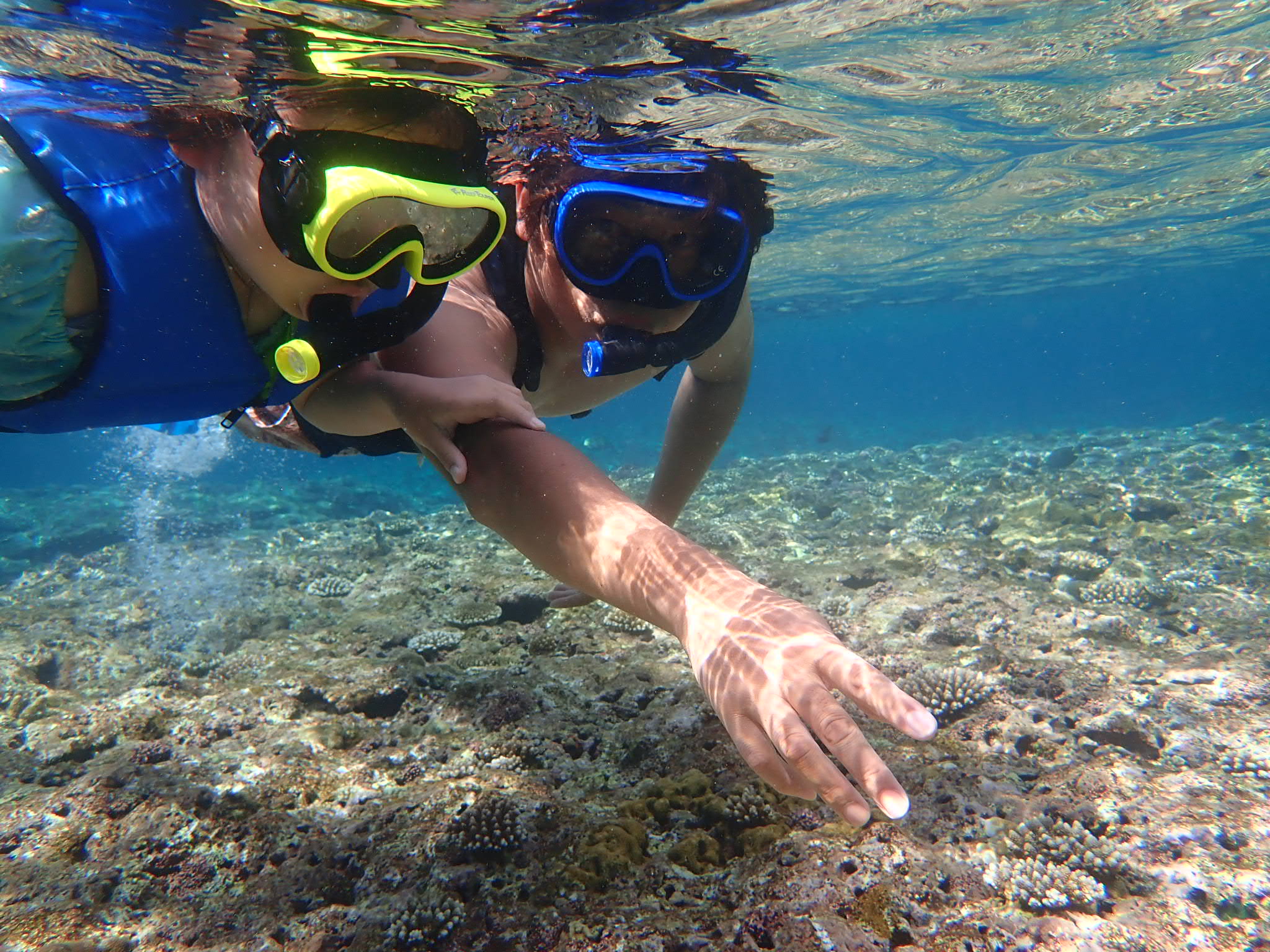 沖縄の国頭村の透明度の高い海で泳ぐ子ども