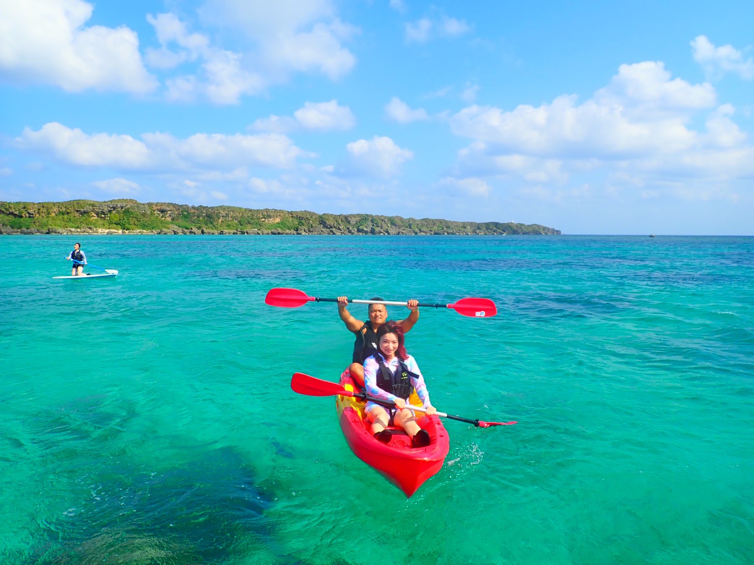 沖縄のやんばるの海をシーカヤックで進むカップル