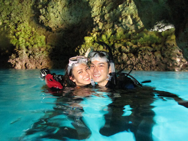 沖縄の青の洞窟で体験ダイビングツアーに参加するカップル
