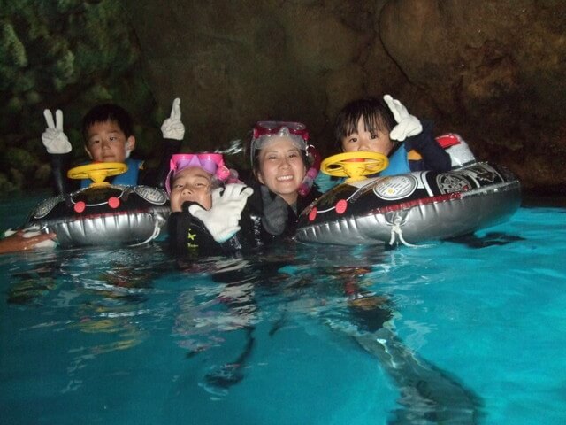 沖縄の青の洞窟でシュノーケリングツアーに参加する子どもたち