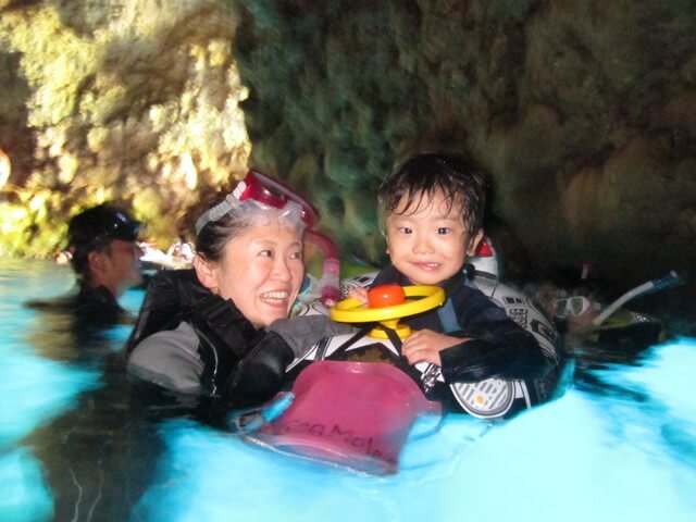 沖縄の青の洞窟でシュノーケリングをする親子