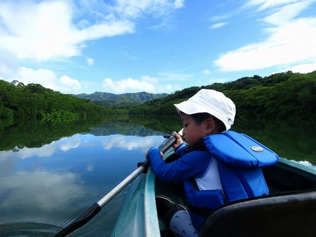 西表島のマイラ川でカヌーをする子供